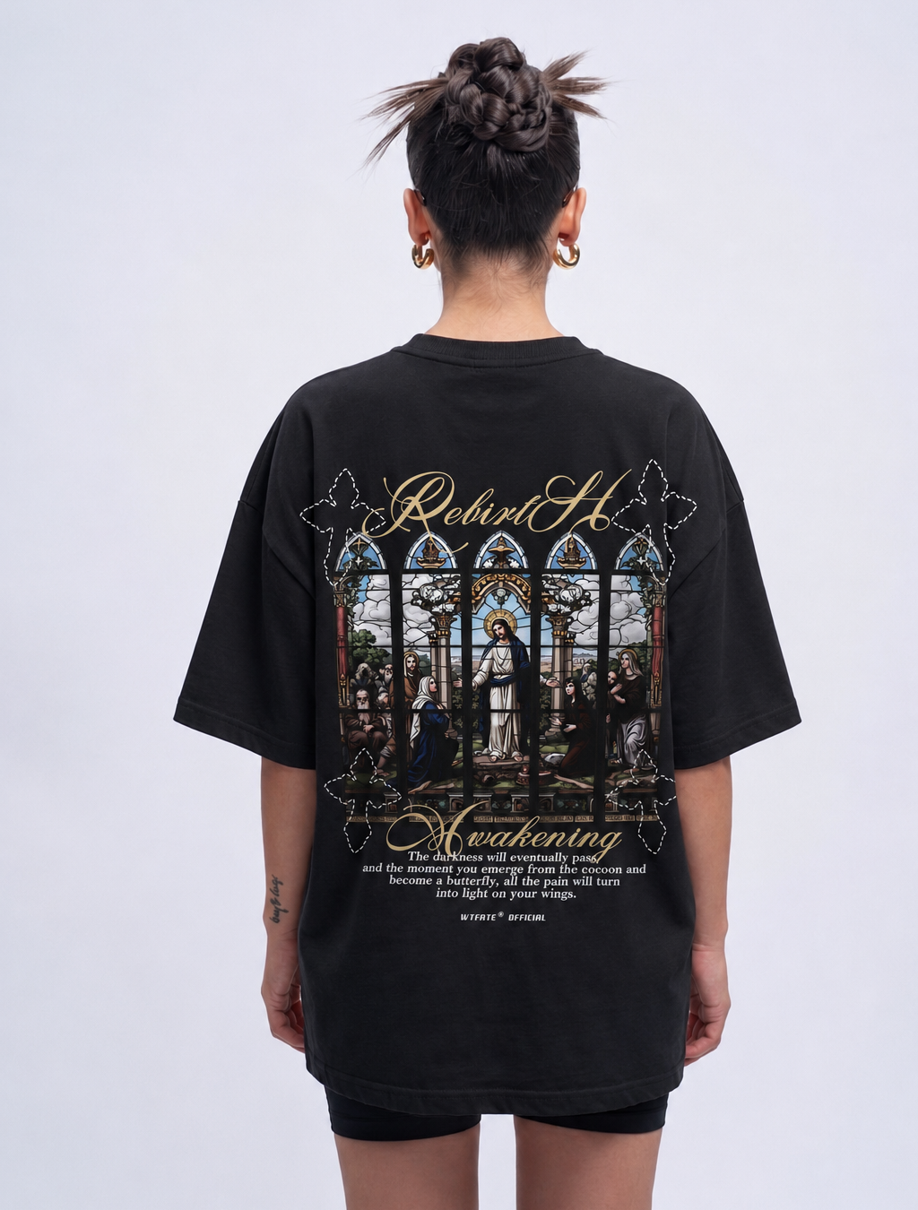 Person wearing a black t-shirt with a detailed design on the back against a white background