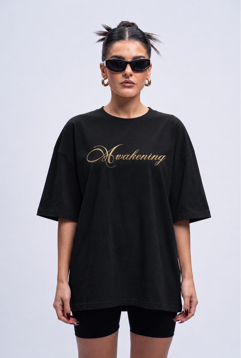 Person wearing a black t-shirt with 'Awakening' printed in gold on a plain background