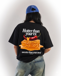 Person wearing a black t-shirt with a graphic and text, standing against a plain background