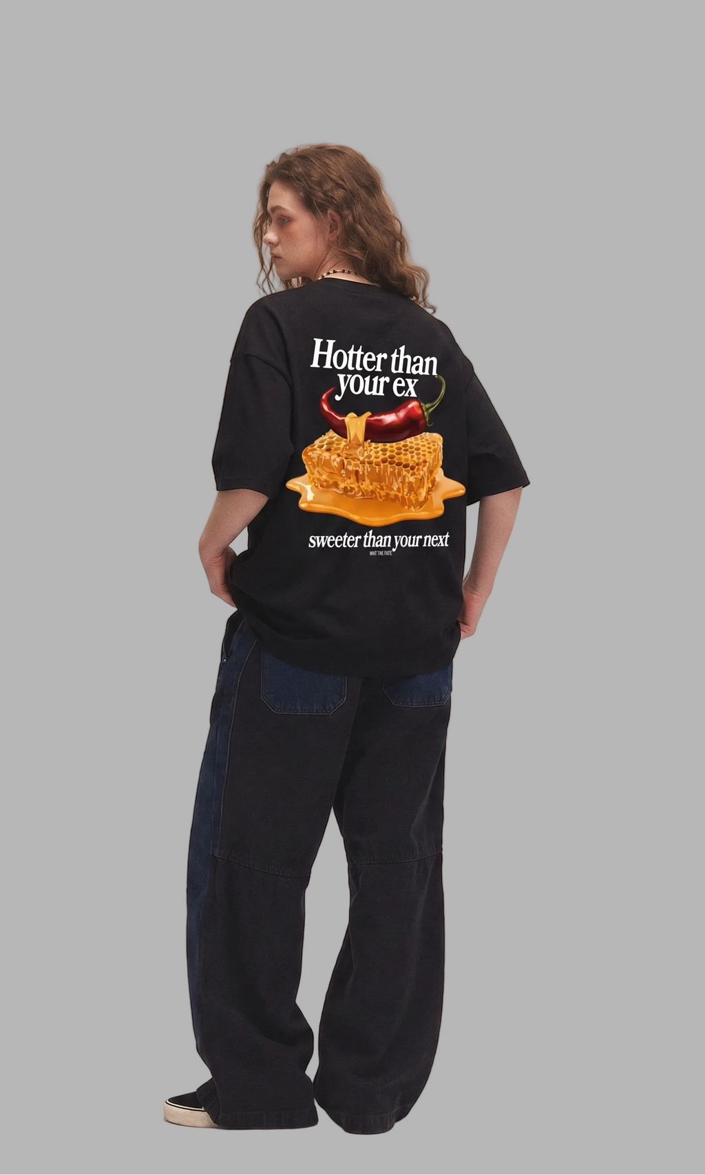 Person wearing a black t-shirt with graphic design and text on a gray background