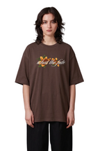 Person wearing a brown t-shirt with text and graphics on a gray background