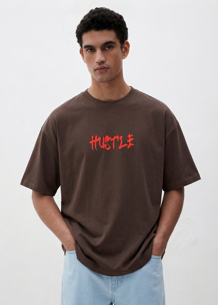 Man wearing a brown t-shirt with 'HUSTLE' in red text on a white background