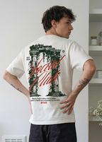 Person wearing a white t-shirt with a graphic design, standing indoors.