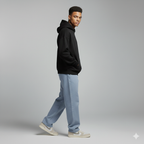 Man wearing a black hoodie and light blue jeans on a gray background