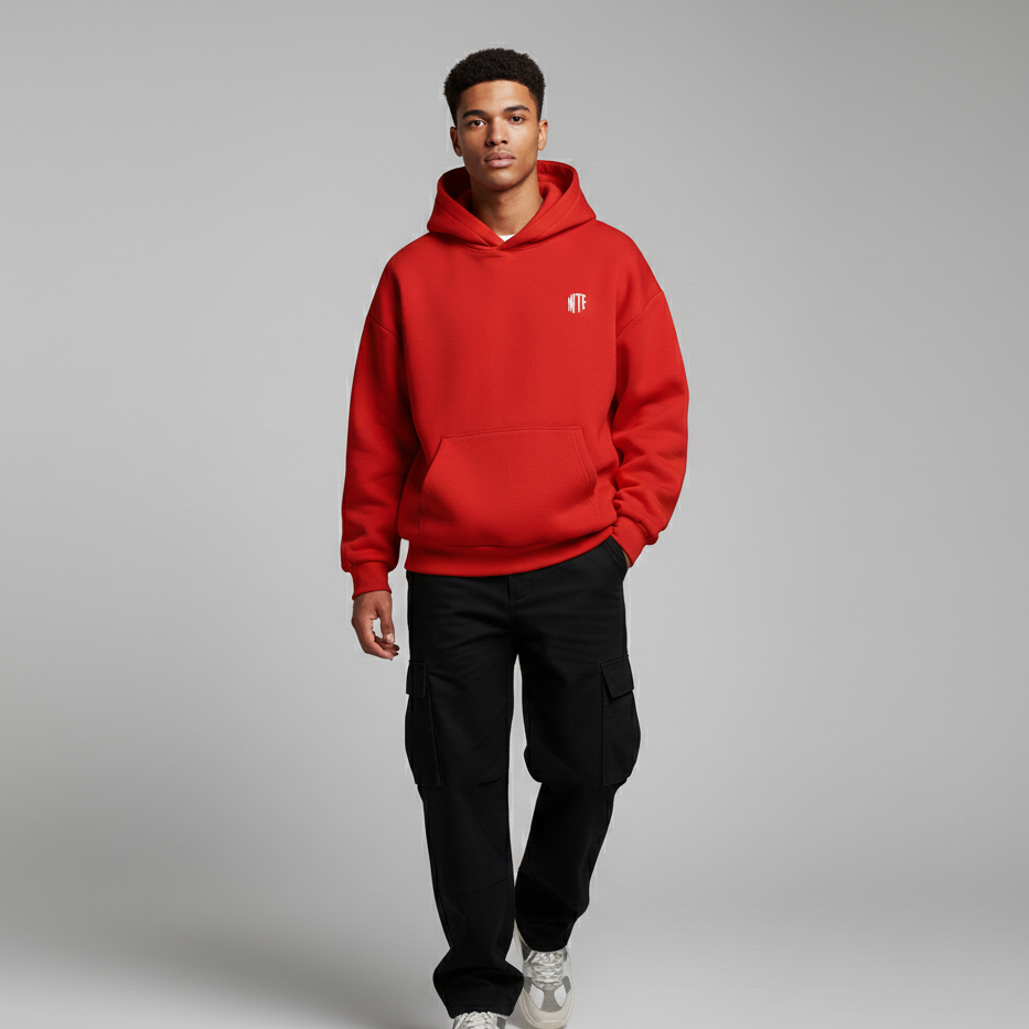 Person wearing a red hoodie with a small logo on a gray background