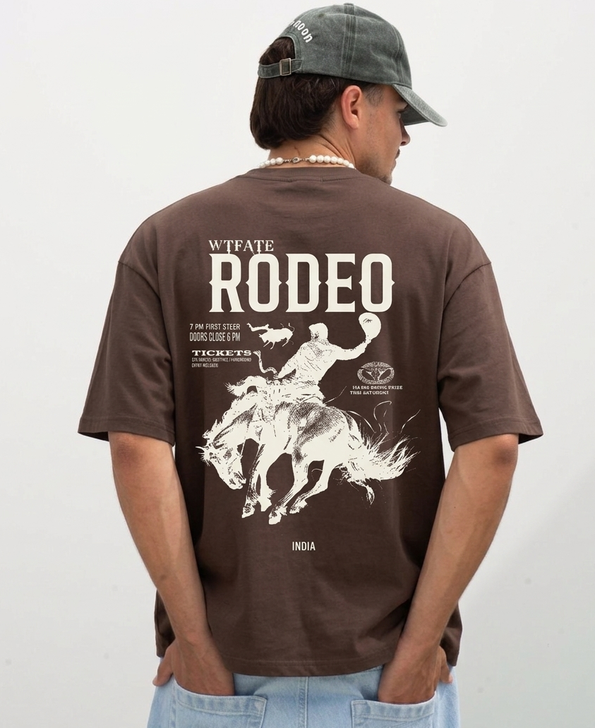 Man wearing a brown t-shirt with a rodeo graphic and text on the back, standing against a plain background.