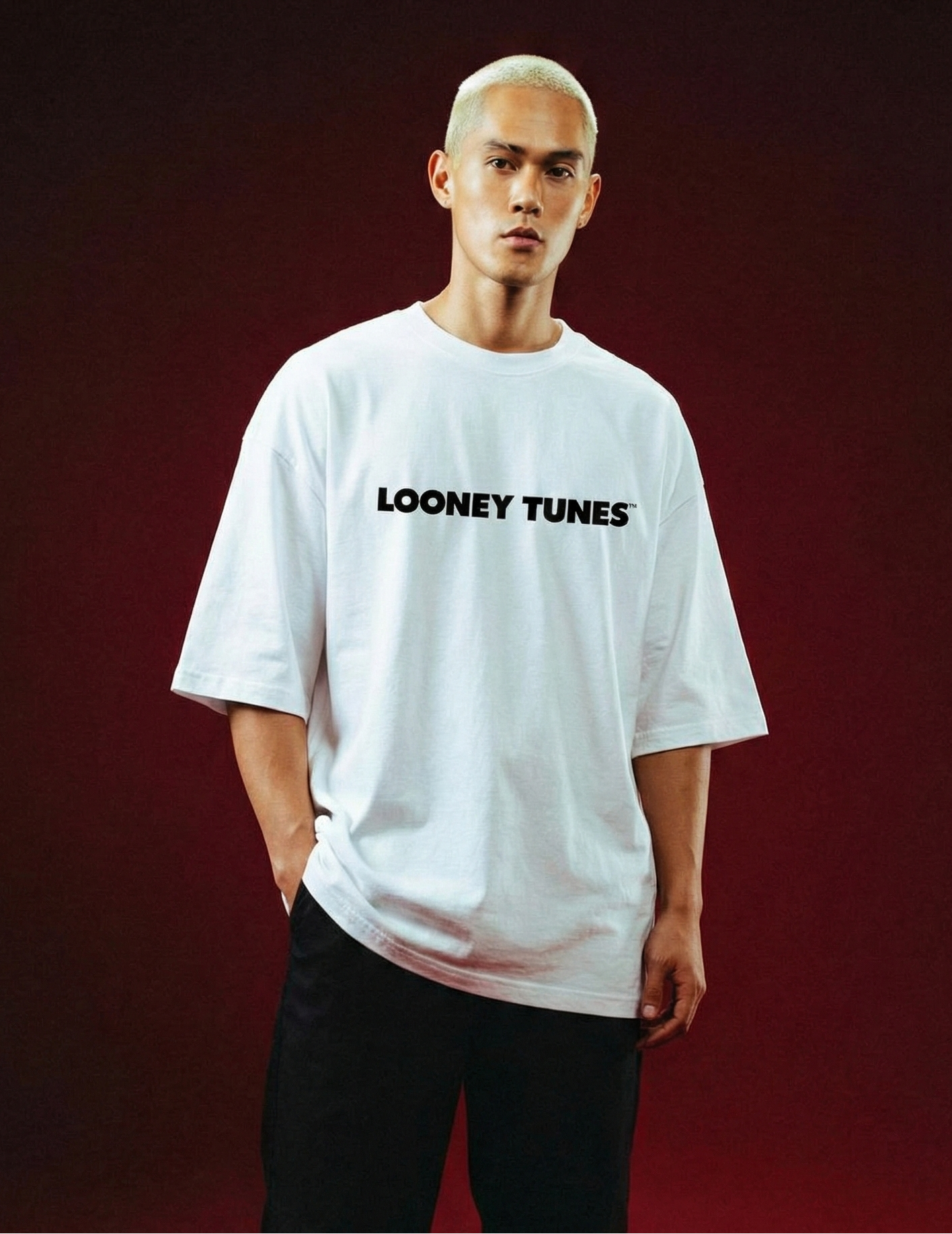 Person wearing a white 'Looney Tunes' t-shirt on a red background