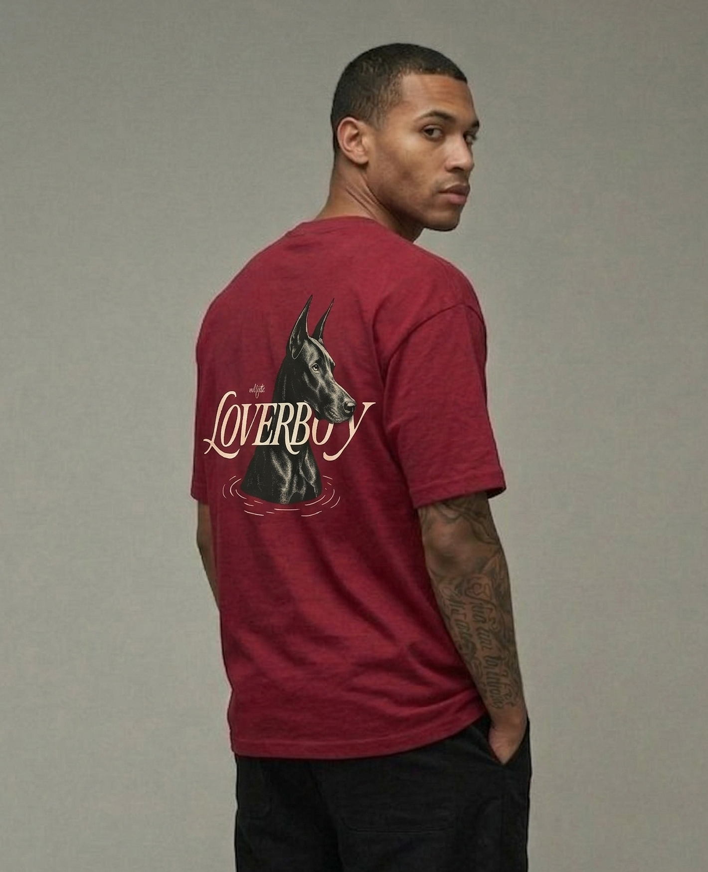 Man wearing a red t-shirt with 'Loverboy' design on the back against a gray background