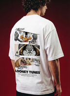 Person wearing a white t-shirt with Looney Tunes graphics on the back against a red background