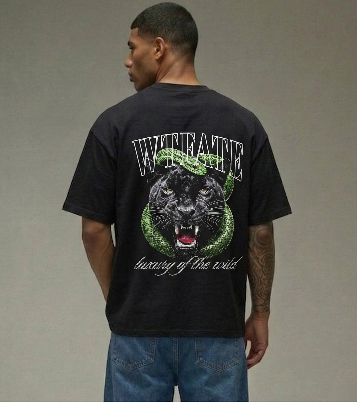 Person wearing a black t-shirt with a panther graphic and text on the back, standing against a plain background.