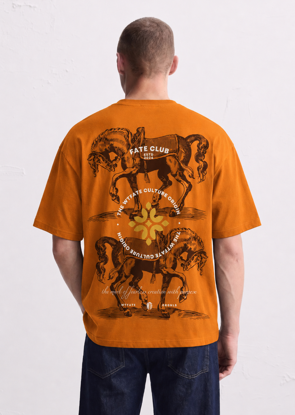Person wearing an orange t-shirt with graphic designs on the back against a white background