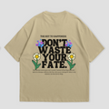 WHAT THE FATE Don't Waste Your Fate oversized t-shirt in black, with 'The Key to Happiness' text on the front and motivational message with flowers and butterflies on the back, 240 GSM terry cotton
