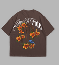 Brown t-shirt with floral and text design on a gray background
