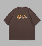 Brown t-shirt with floral and text design on a gray background