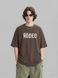Person wearing a brown 'Rodeo' t-shirt on a gray background