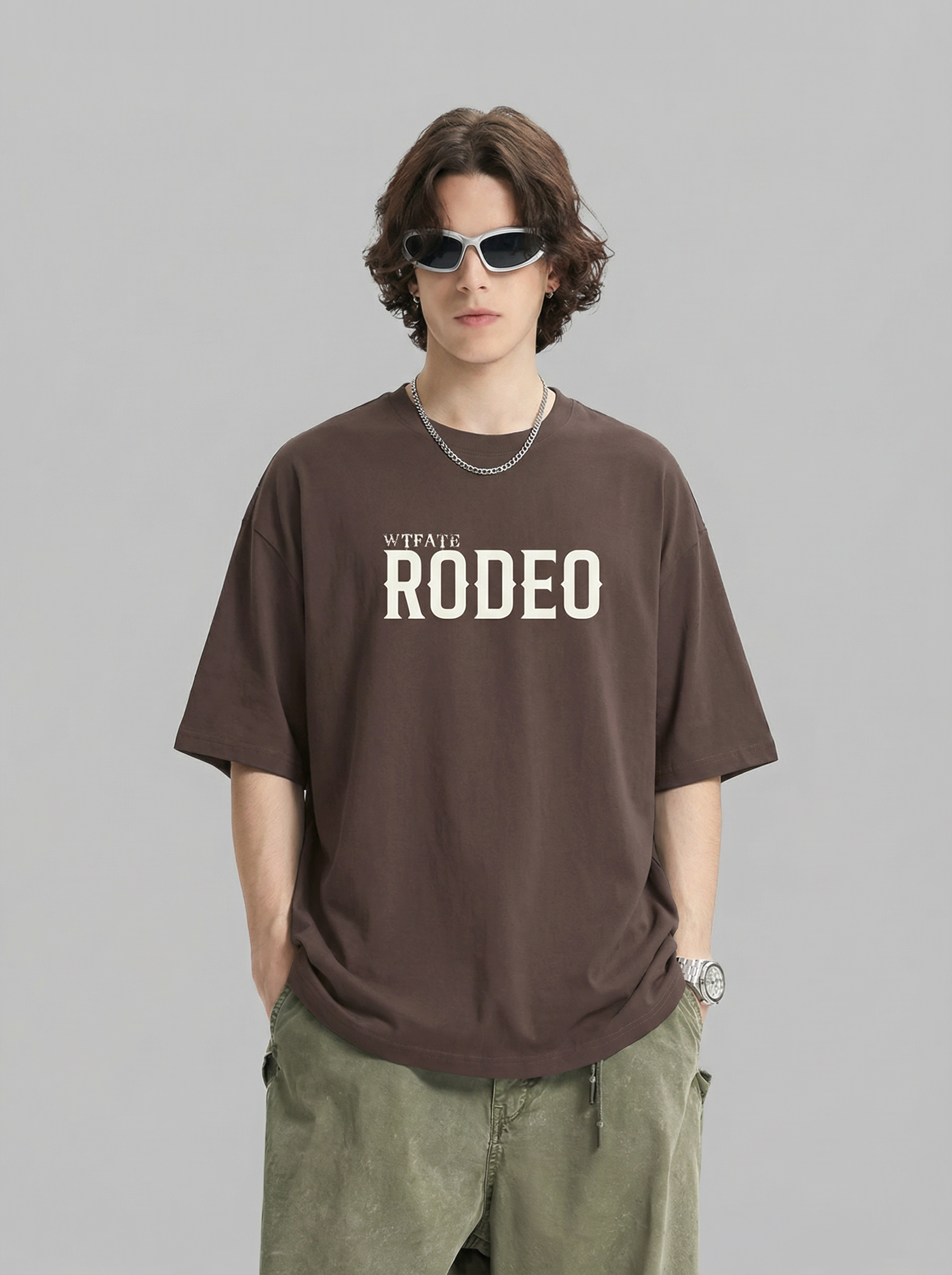 Person wearing a brown 'Rodeo' t-shirt on a gray background