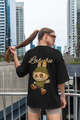 Woman wearing black oversized Labubu limited edition shirt with cartoon character on back in urban setting
