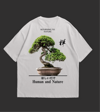 Two white t-shirts with a bonsai tree design and text on a black background