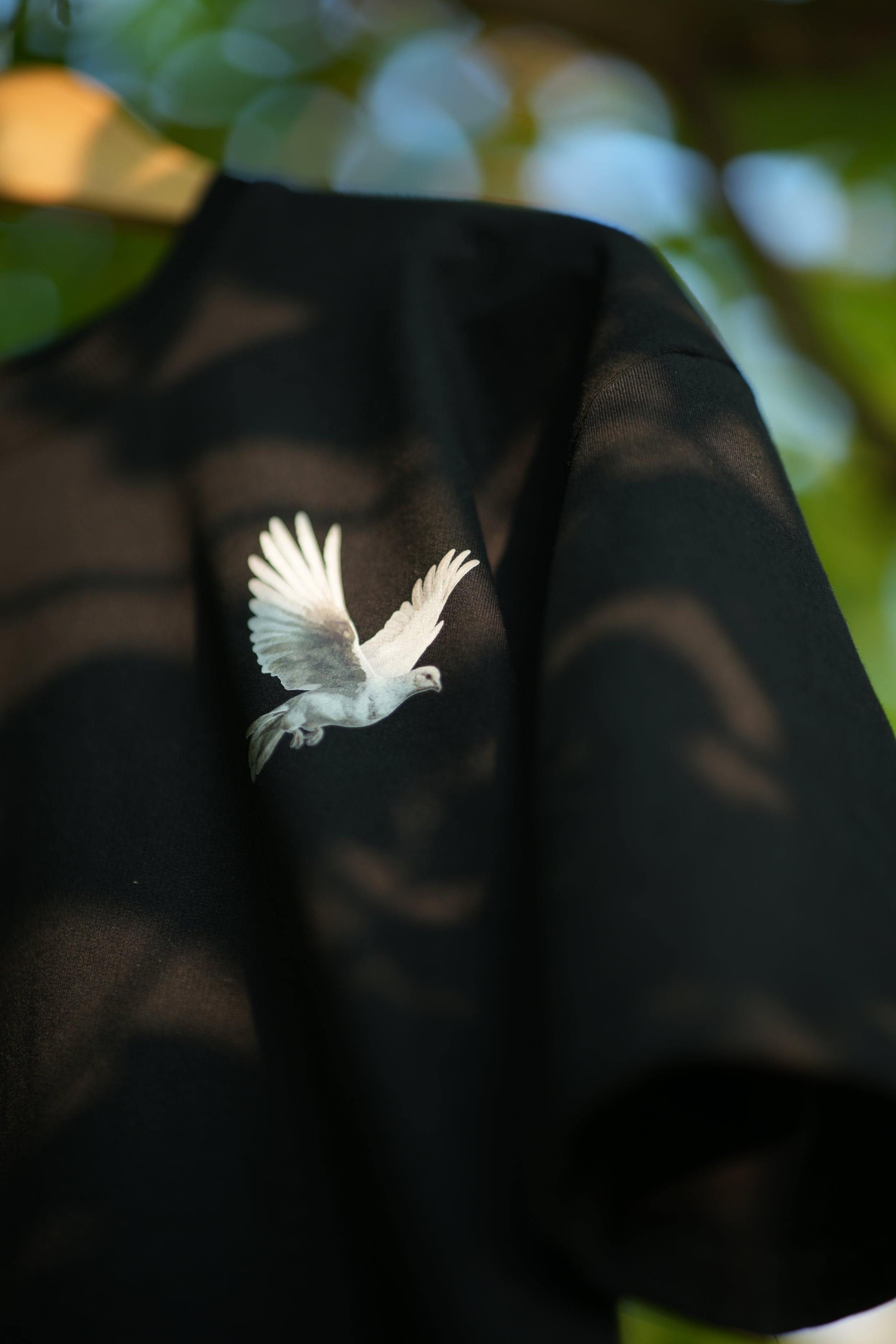 Pigeons of Fate cotton tee featuring a white dove graphic on a black shirt for bold streetwear style
